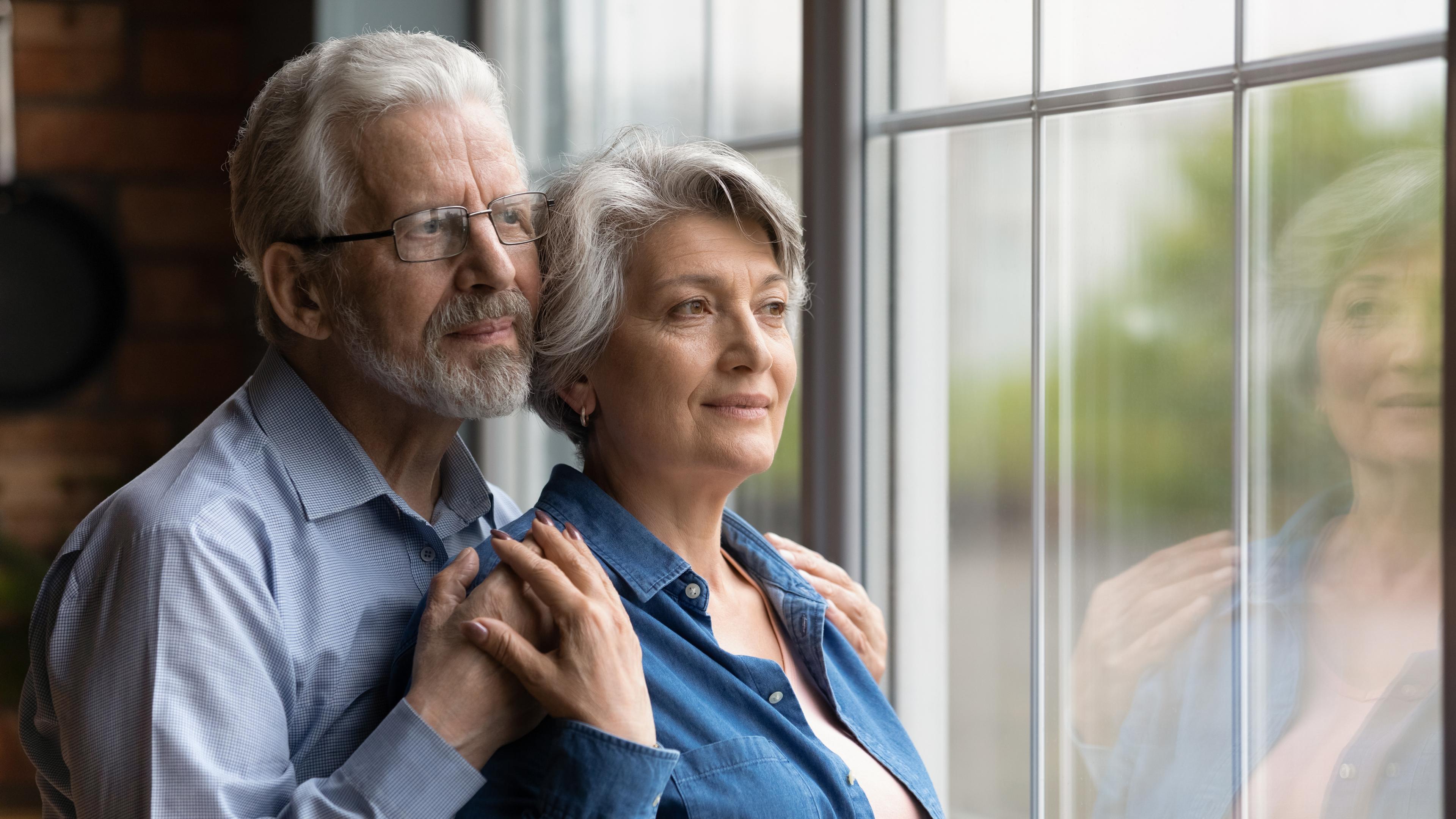 Couple holding hands looking out a window
