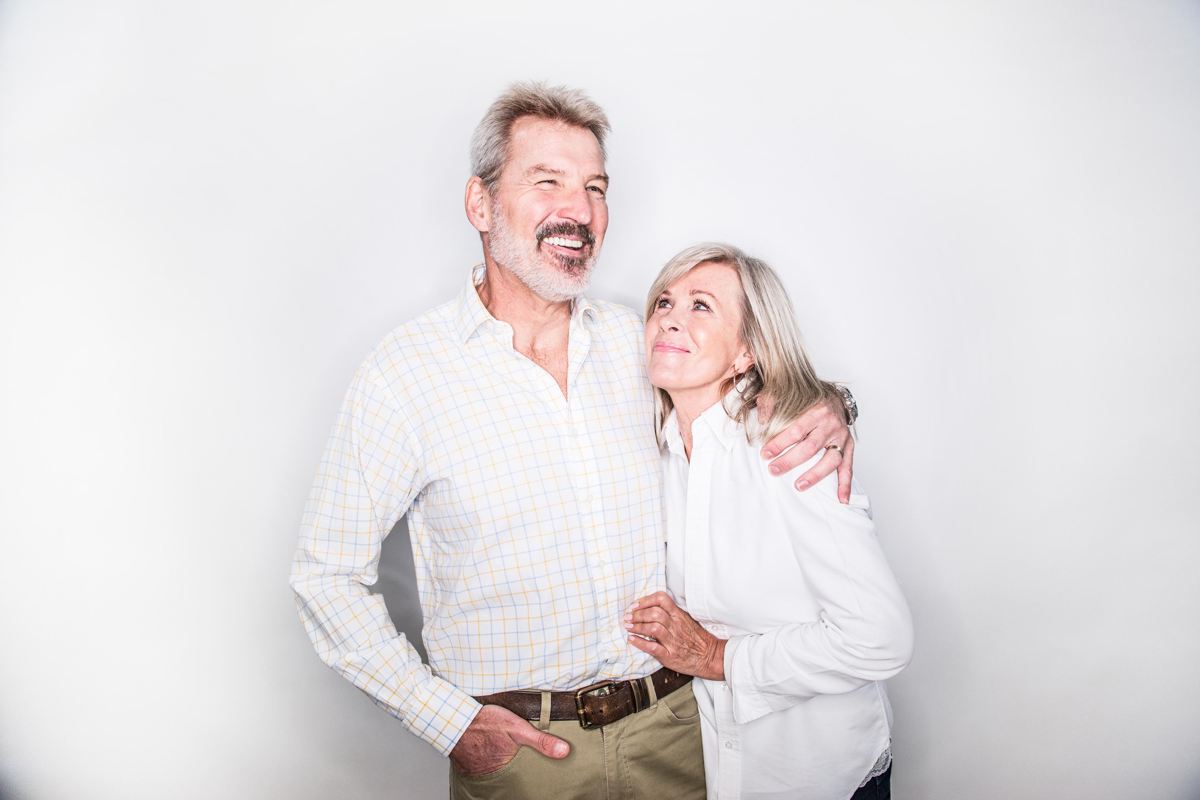 Old couple in white shirts hugging