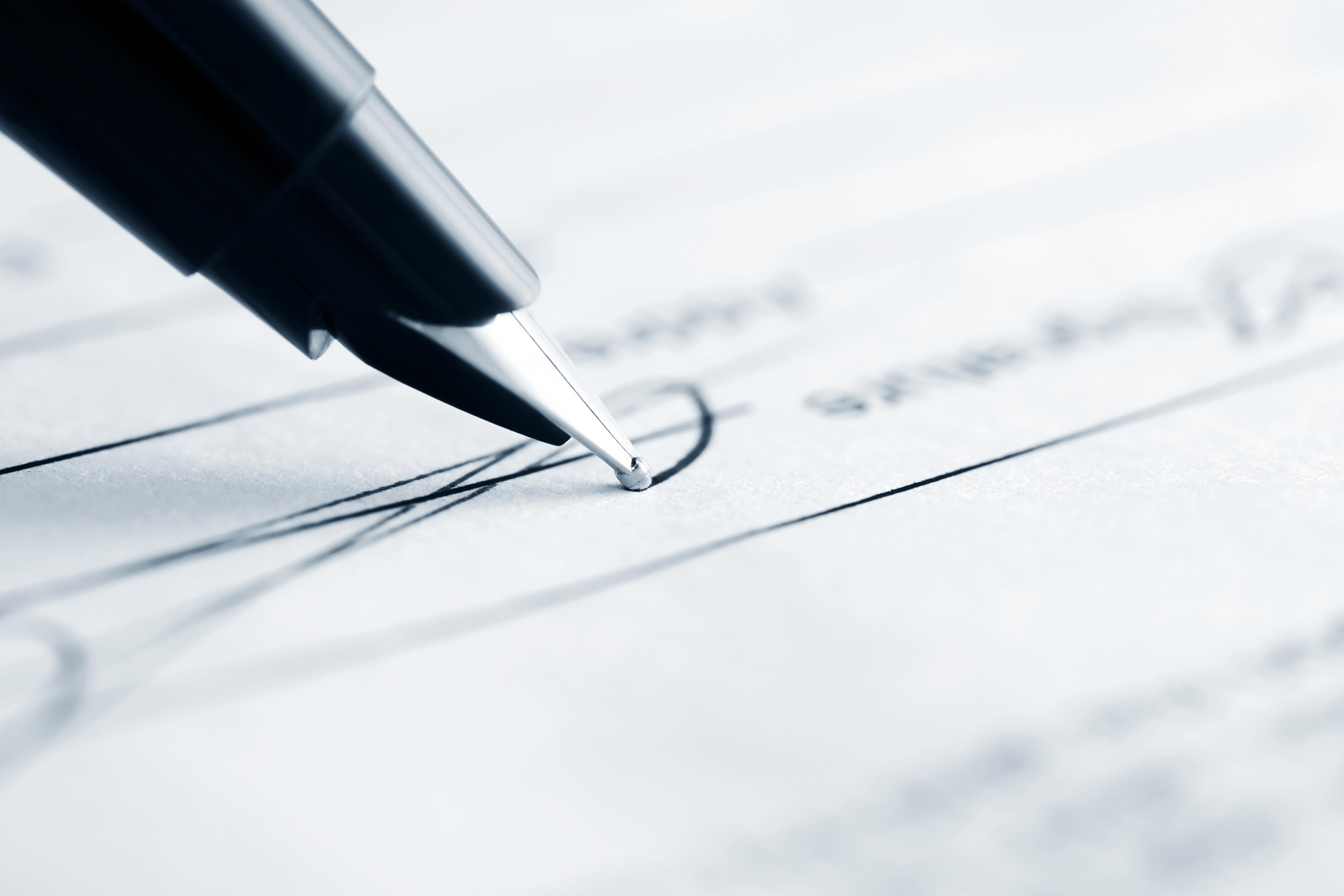 Close up of pen signing a check