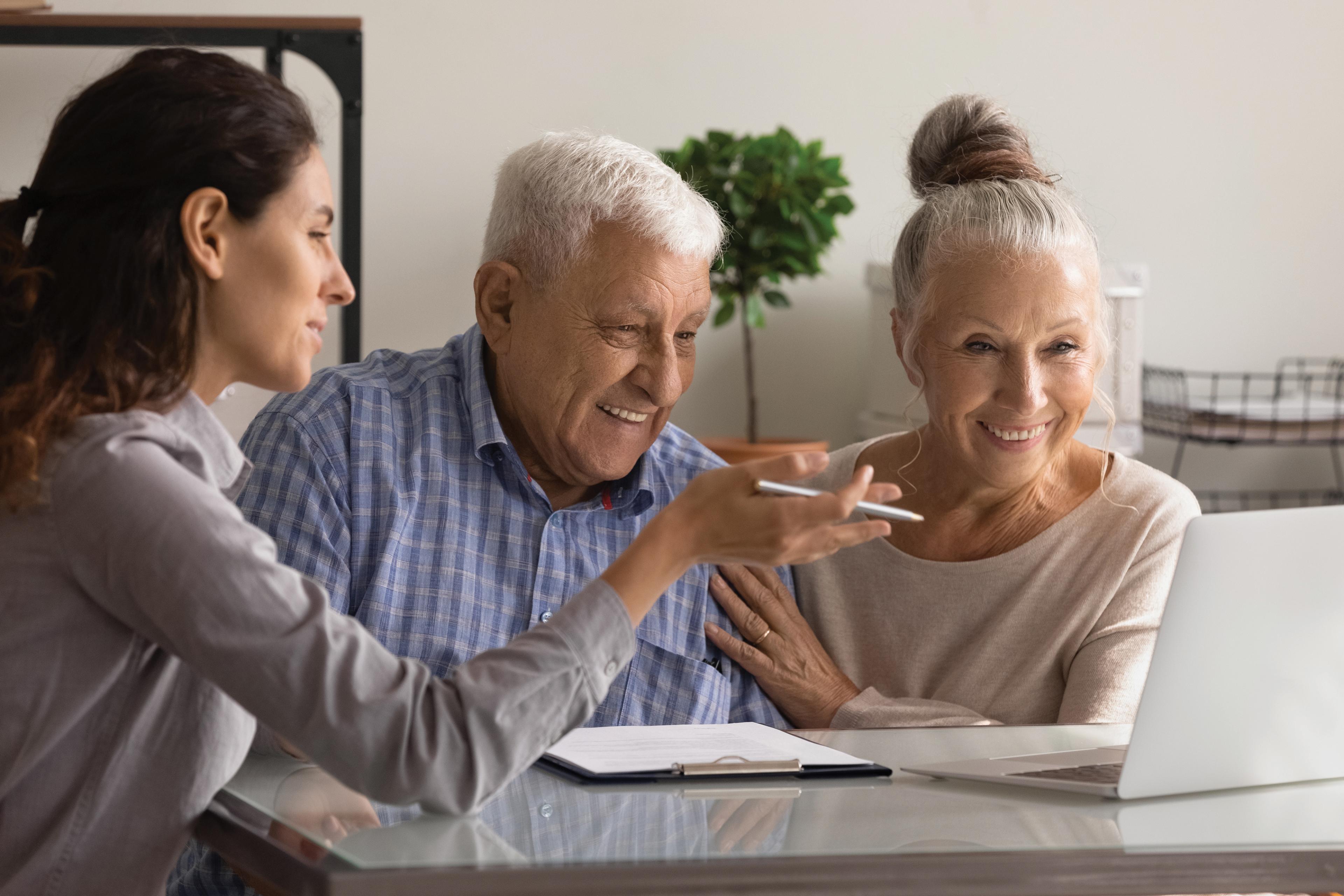 Elderly couple with their adult daughter holding hands